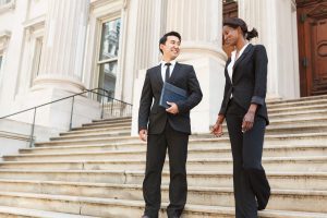 A man and woman in professional attire on the steps of a government building