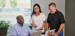 DocPoint employees meeting around a laptop